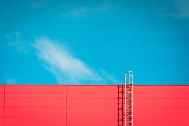 A,Red,Modern,Facade,Of,An,Industrial,Building,,Warehouse,Or
